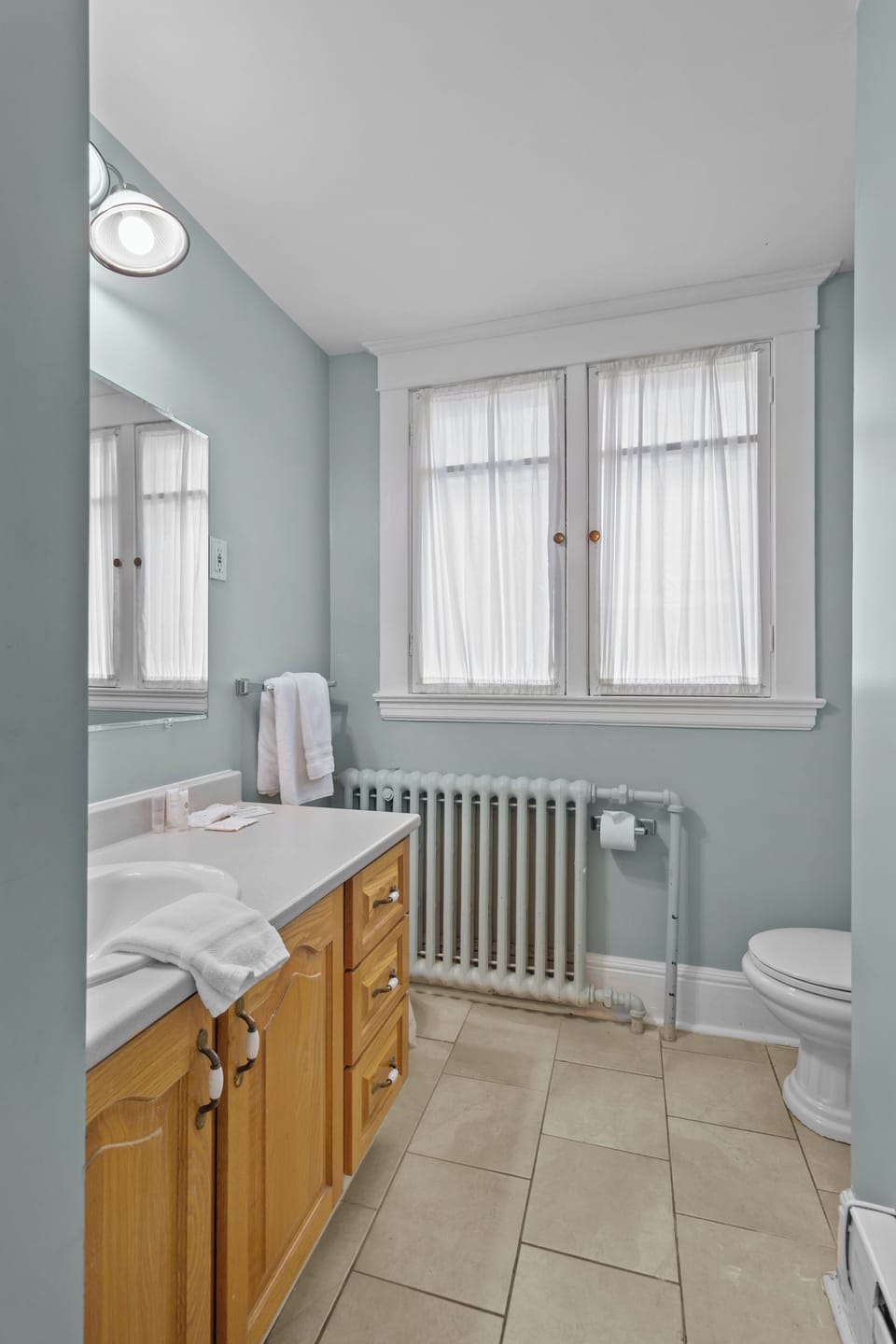 Clean bathroom with natural light and fresh towels provided