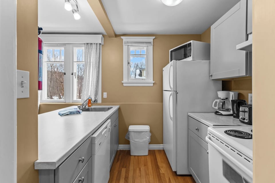 Sleek Kitchen Workspaces. Functional and clean, this kitchen offers everything you need, from a coffee maker to a convenient double sink setup.