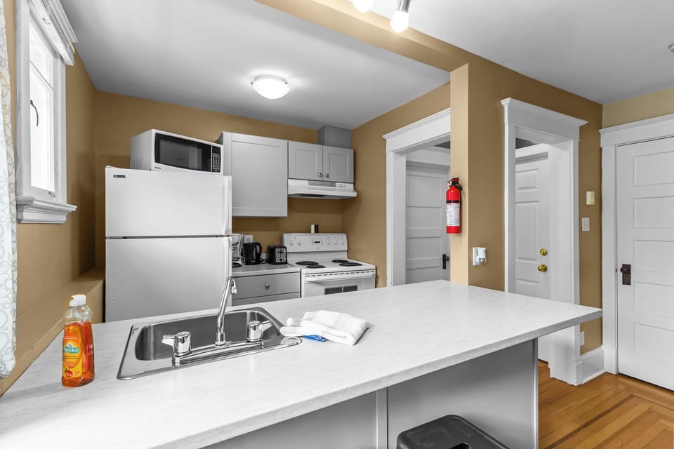 Fully Equipped Modern Kitchen. The heart of the home, complete with a full-sized stove, microwave, refrigerator, and plenty of counter space for cooking.