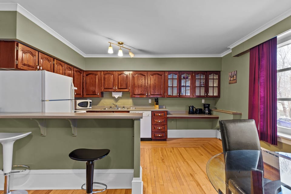Breakfast Bar & Kitchen: View of the functional kitchen layout showing the convenient breakfast bar seating, perfect for quick bites or chatting with the cook.