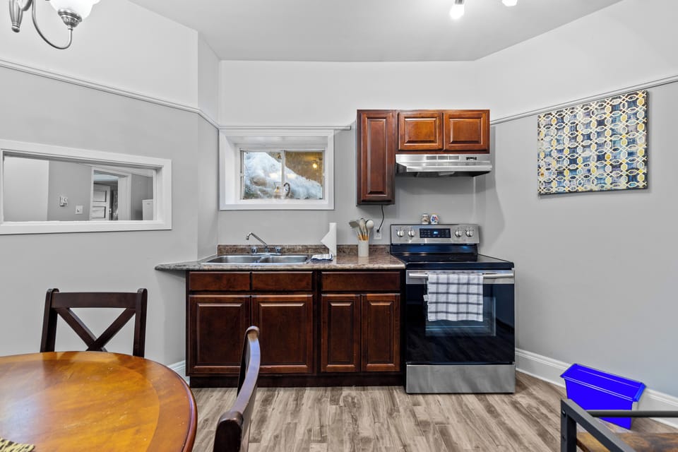 Kitchen Detail: Modern kitchen featuring dark wood cabinetry, a full-sized stove, and plenty of counter space for meal prep.