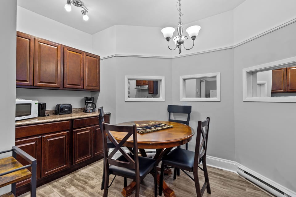 Dining Area: A secondary view of the intimate dining space, featuring modern lighting and view-through windows to the kitchen.