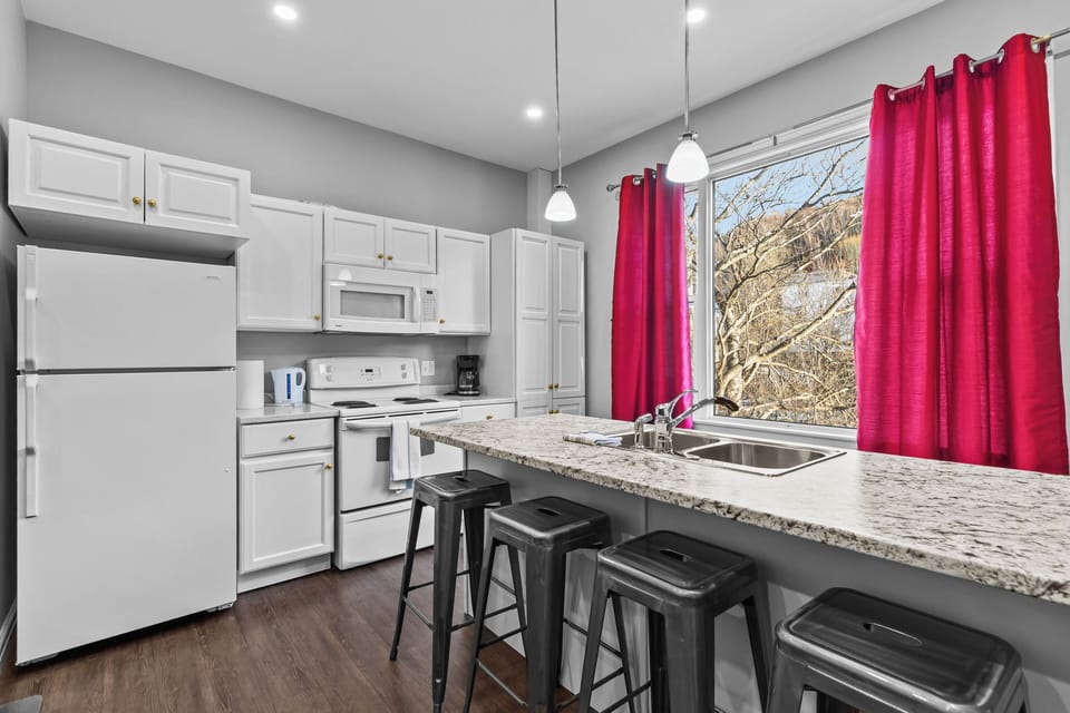 Kitchen Detail: Fully equipped kitchen with a double sink, microwave, and ample counter space, perfect for preparing home-cooked meals.