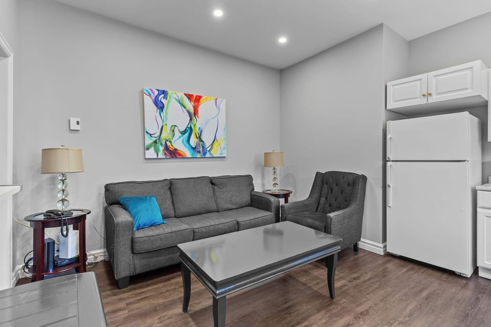 Seating Area: Secondary view of the living space showing the comfortable sofa and armchair, ideal for gathering with friends or family.