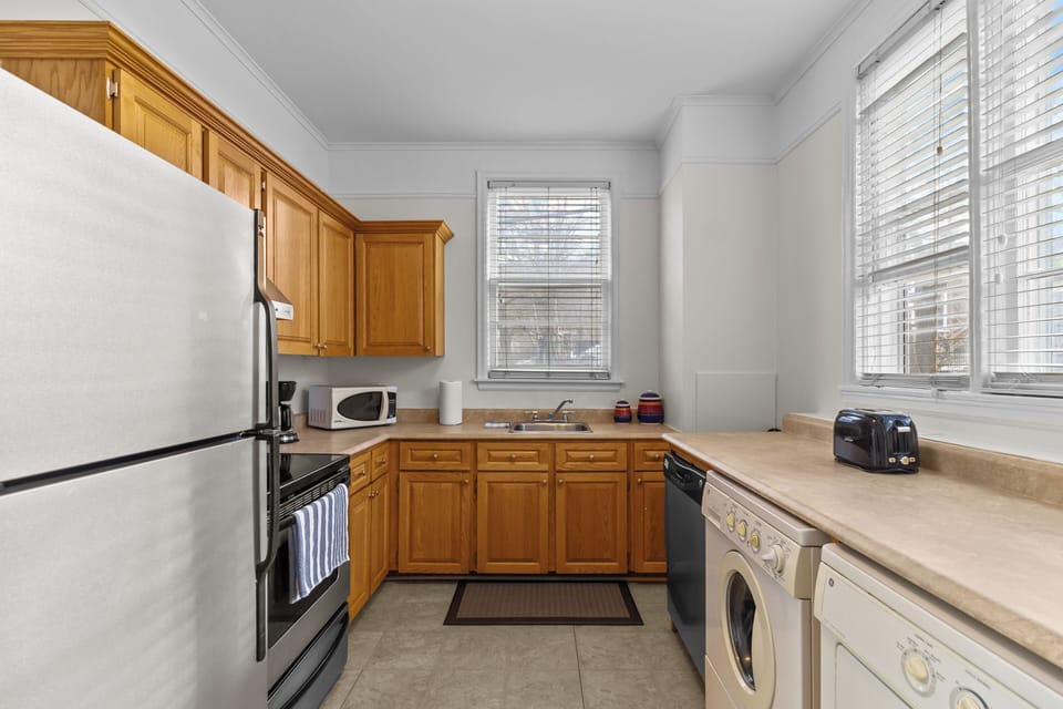Well-stocked kitchen with wood cabinetry, a microwave, and essential cookware. Everything you need for a short or long-term stay.