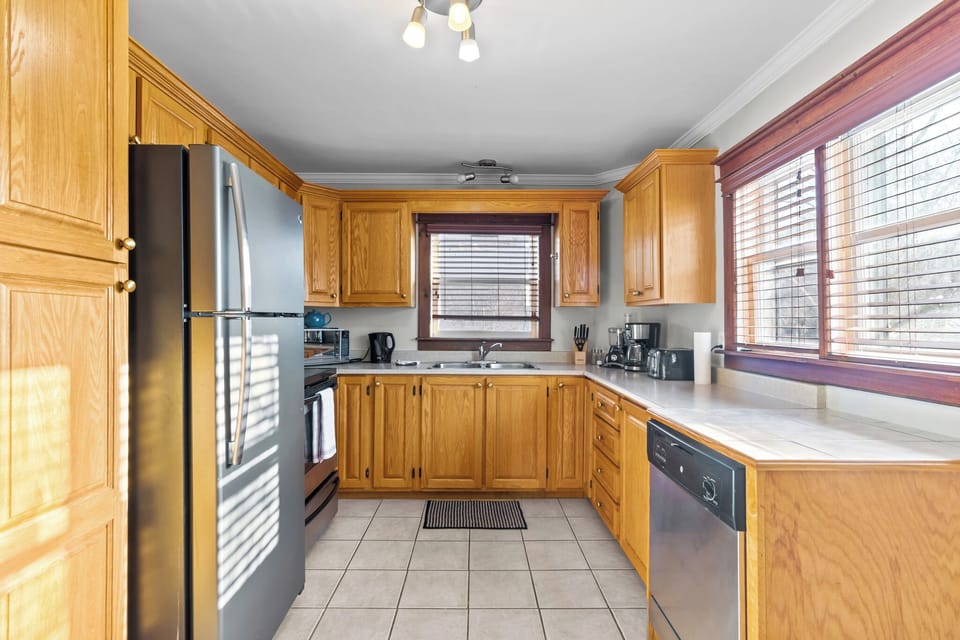 A bright kitchen equipped with stainless steel appliances, ample oak cabinetry, and plenty of counter space for preparing home-cooked meals.