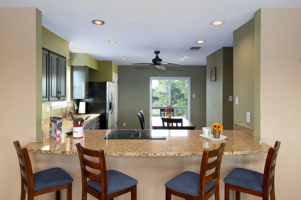 A bar with seating for four overlooks the kitchen and dining area, making it easy to cook, serve, and connect.