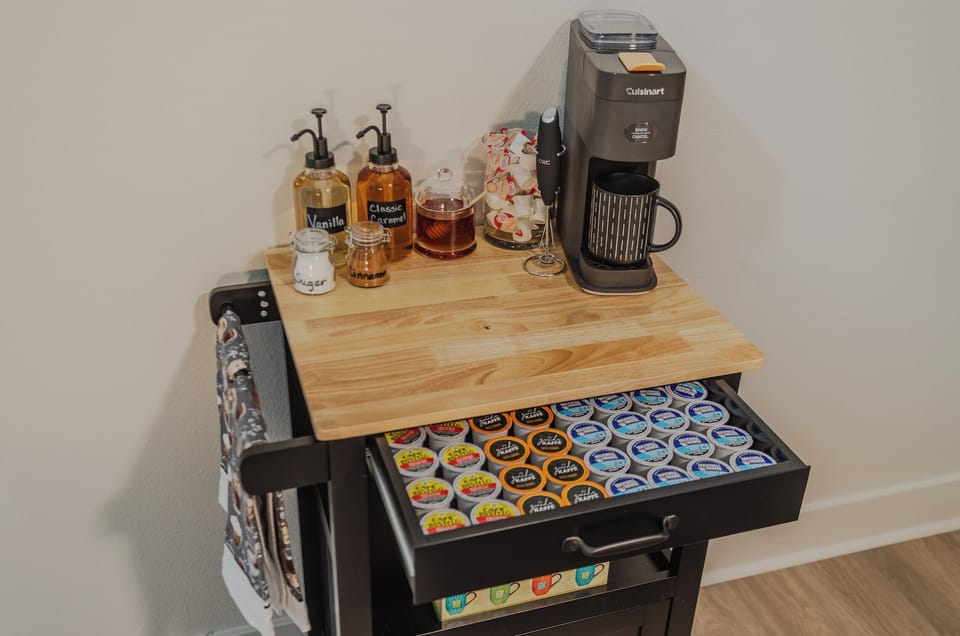 In-room coffee bar with brewer, K-cups, syrups, and spices for a cozy start.