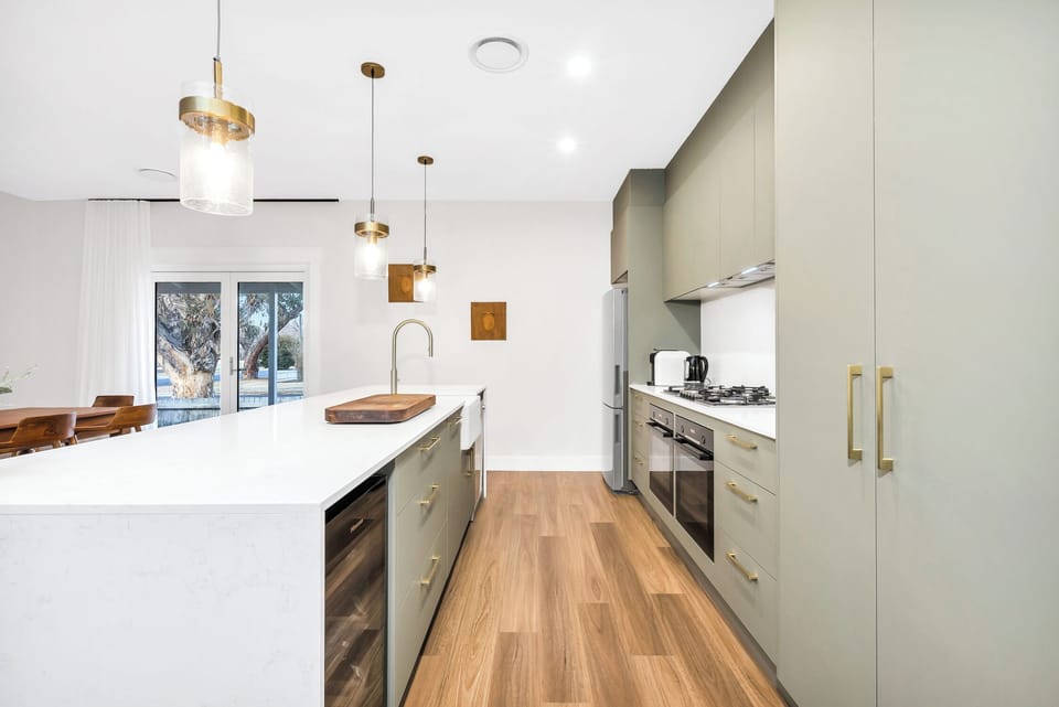Kitchen includes double ovens, farmhouse sink and even a wine fridge