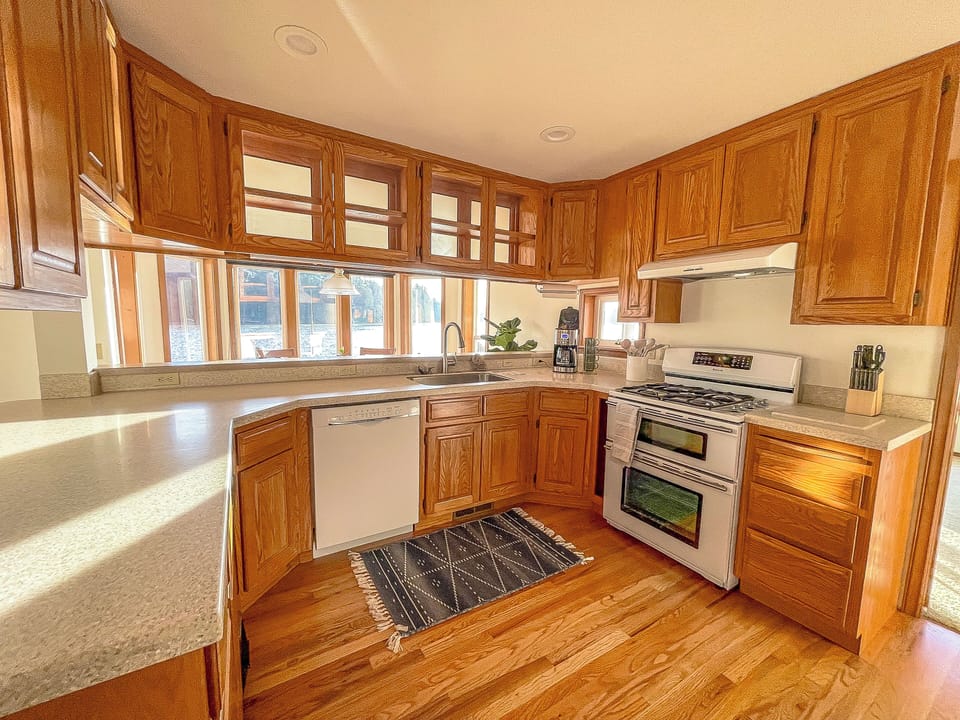 Fully-stocked kitchen with gas stove, dual ovens, and quality cookware.
