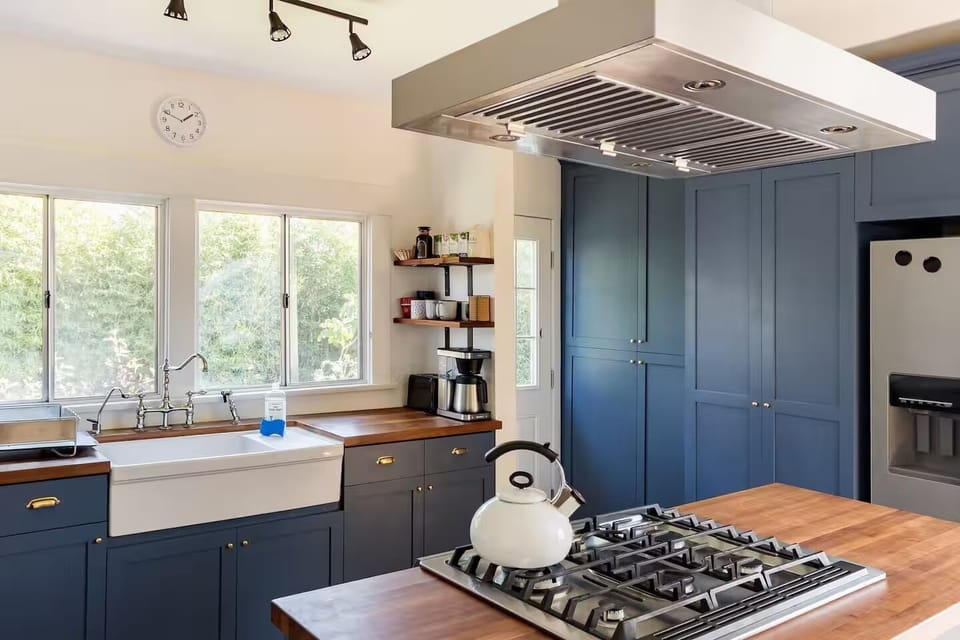 A fully stocked kitchen with dishwasher and stacked washer and dryer.
