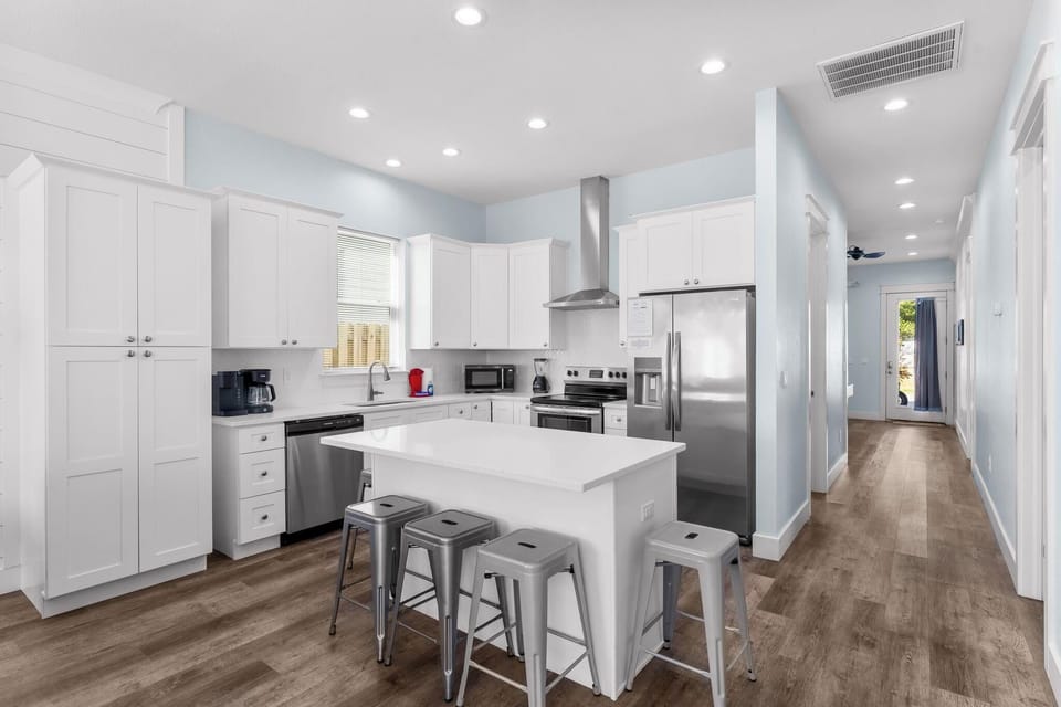 Modern kitchen with bar seating and stainless steel appliances.