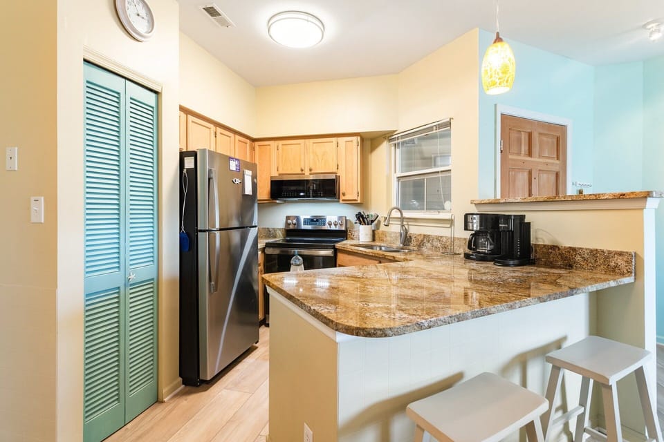 Dining Area & Kitchen: Fully equipped kitchen with breakfast bar and dining space for four, ideal for casual meals as a family.