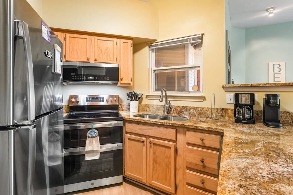 Dining Area & Kitchen: Fully equipped kitchen with breakfast bar and dining space for four, ideal for casual meals as a family.