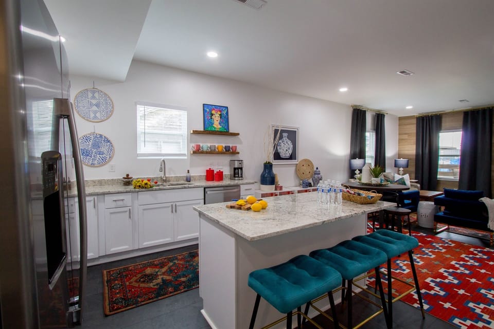Open-concept kitchen with large island and a view into the cozy living room