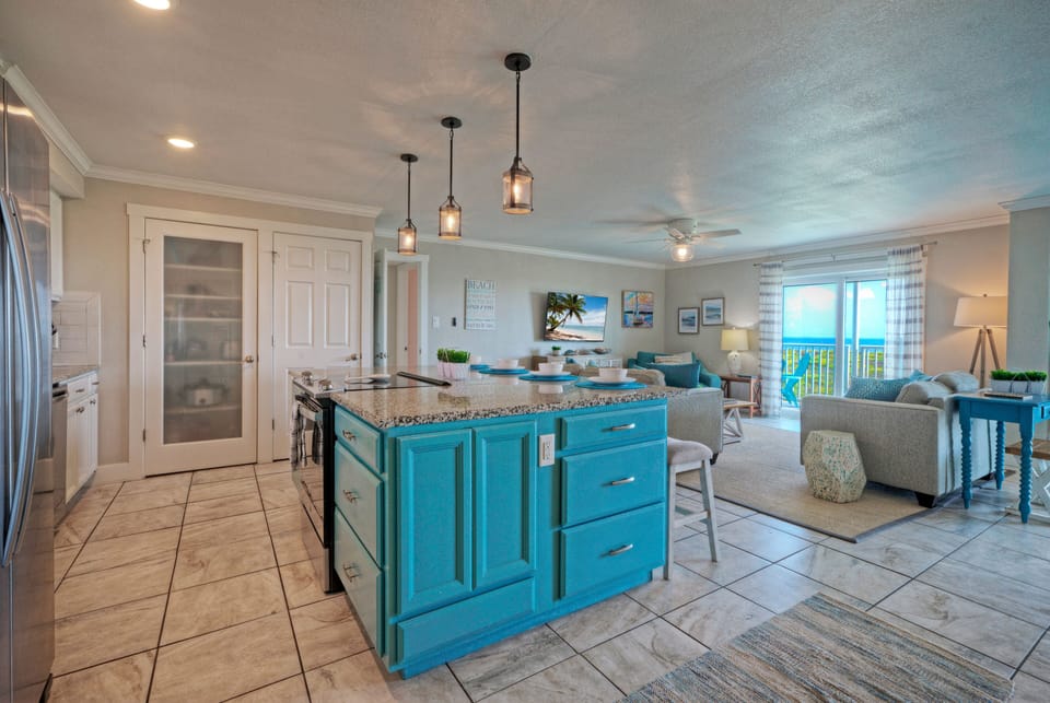 Spacious kitchen with turquoise island seating and a seamless flow into the airy living room.