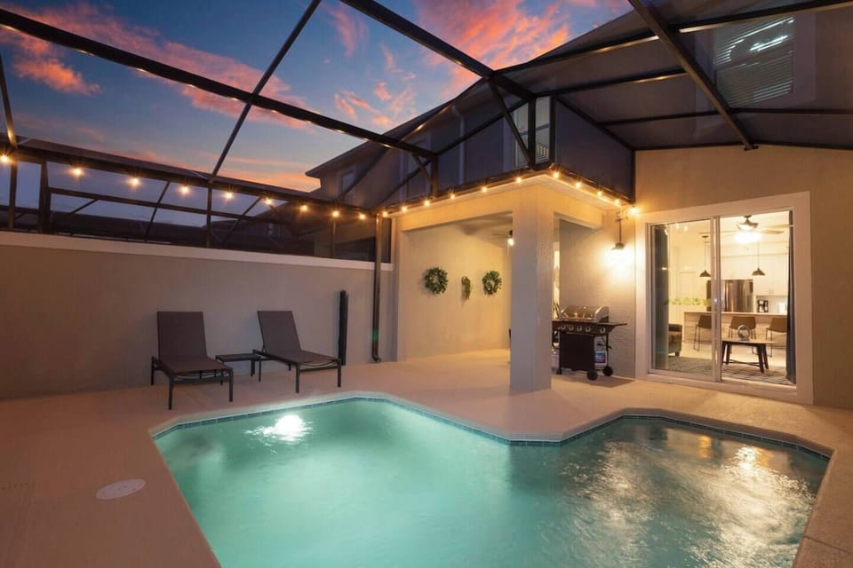 Enjoy a screened private pool with a BBQ grill and comfortable outdoor furniture, perfect for relaxing and dining al fresco.
