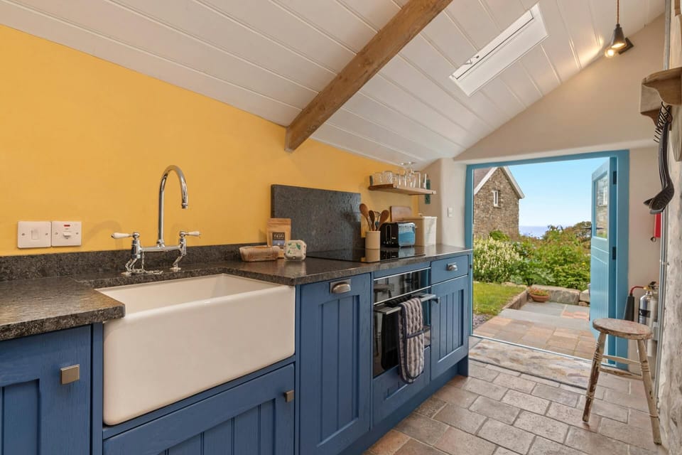 Blue painted base units with Belfast sink. Double doors leading to garden