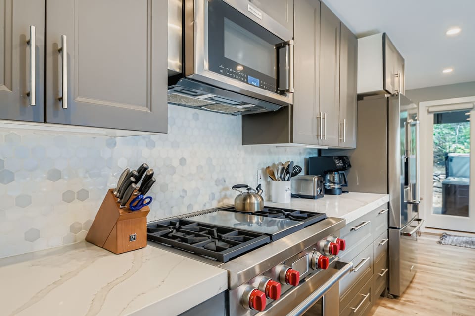 Enjoy a fully stocked kitchen with sleek quartz countertops and a large island, perfect for gathering. Prepare gourmet meals with stainless steel appliances during your Park City getaway.