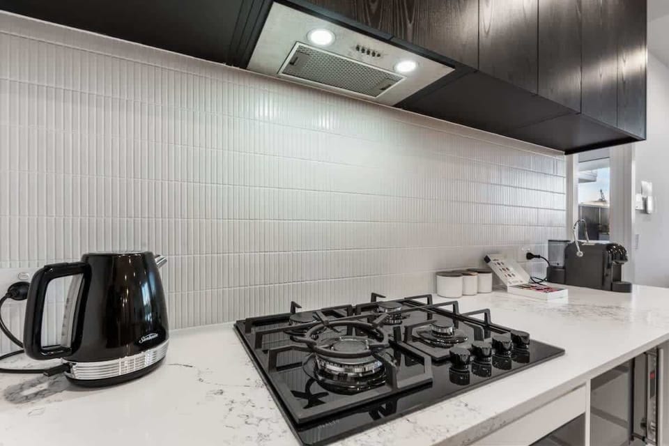 Cooking convenience – Gas cooktop, kettle, and essential utensils ready for home-cooked meals.