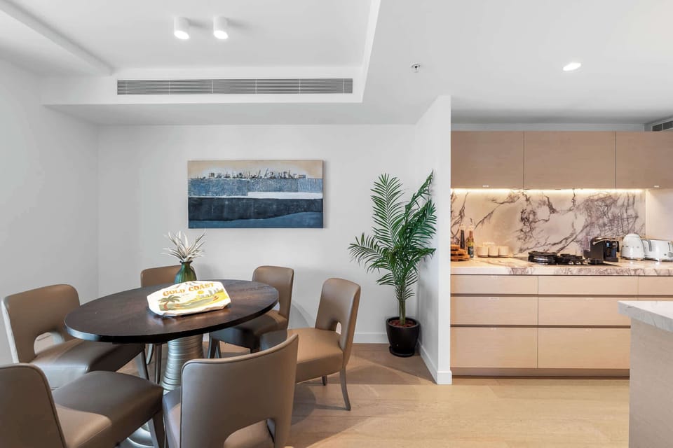 The six-seater dining table provides the perfect space for shared meals or morning coffee, complemented by stylish artwork and greenery.