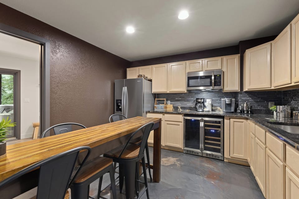 The perfect wet bar and snack station! Our lower-level kitchenette features a full-size refrigerator, dedicated wine fridge, microwave, sink, and a cozy small seating area.