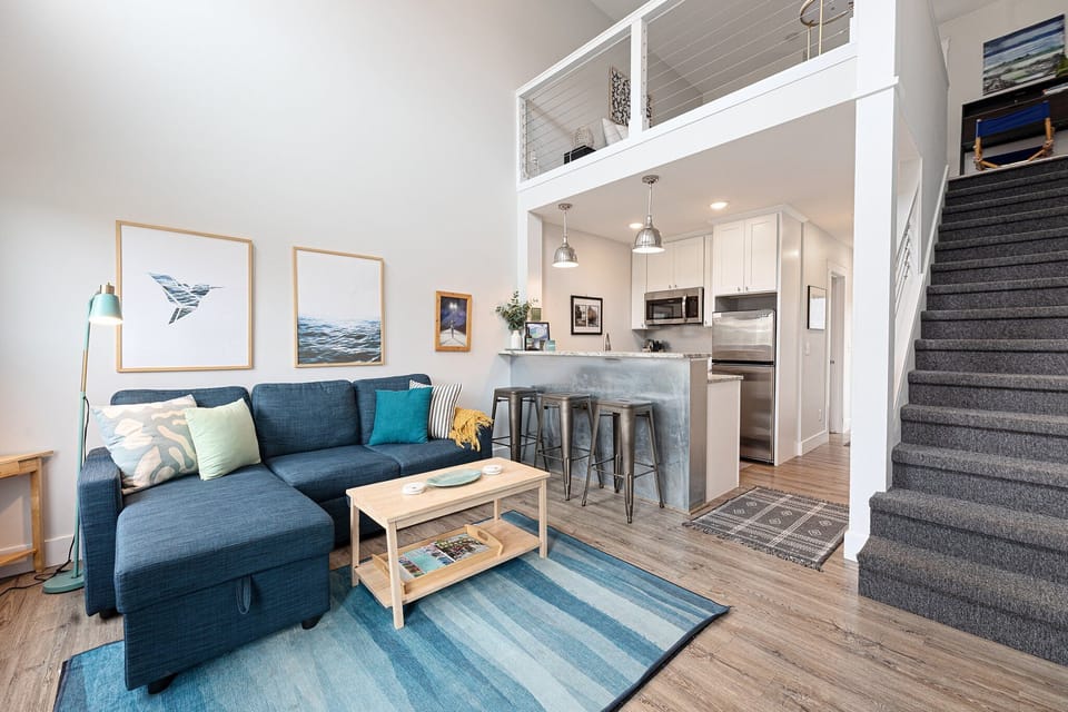 Airy living space w/ lofted ceiling, natural light & room to gather together.