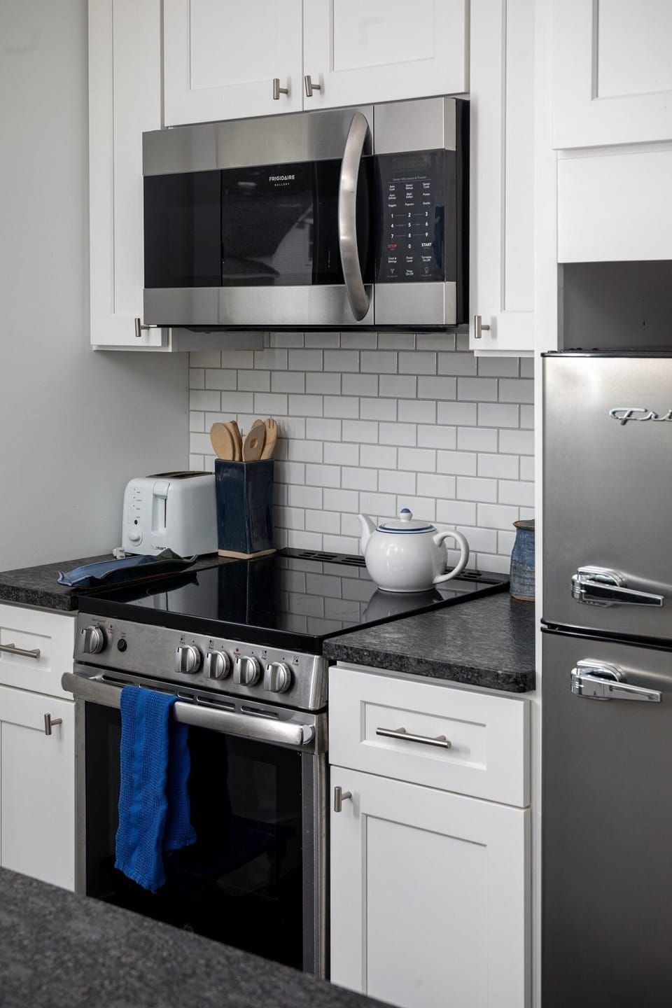 Gas range w/ subway tile backsplash & modern finishes for inspired home cooking.