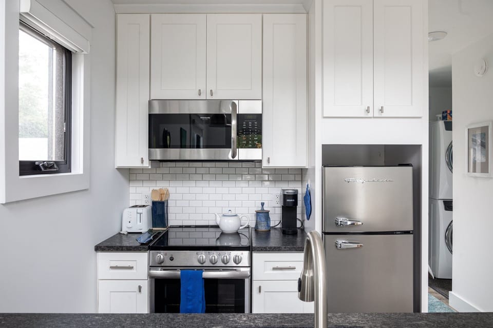 Bright kitchen w/ stainless steel appliances, subway tile backsplash & ample cabinet space.