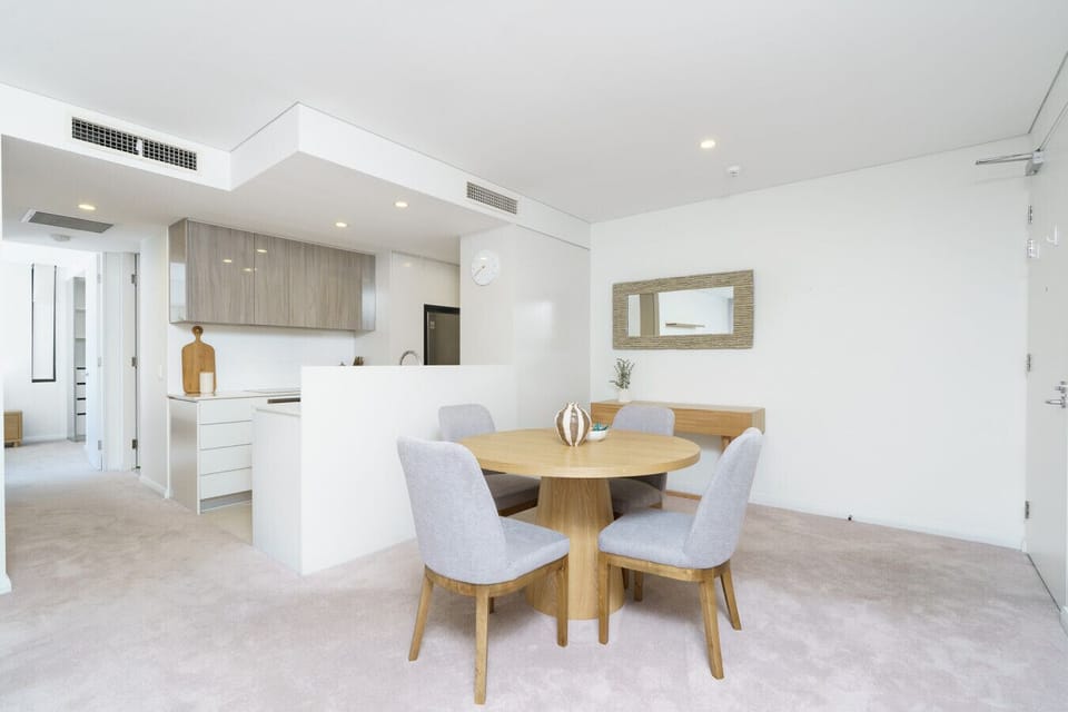 Enjoy meals in a bright dining nook featuring classic wooden furniture and soft décor.