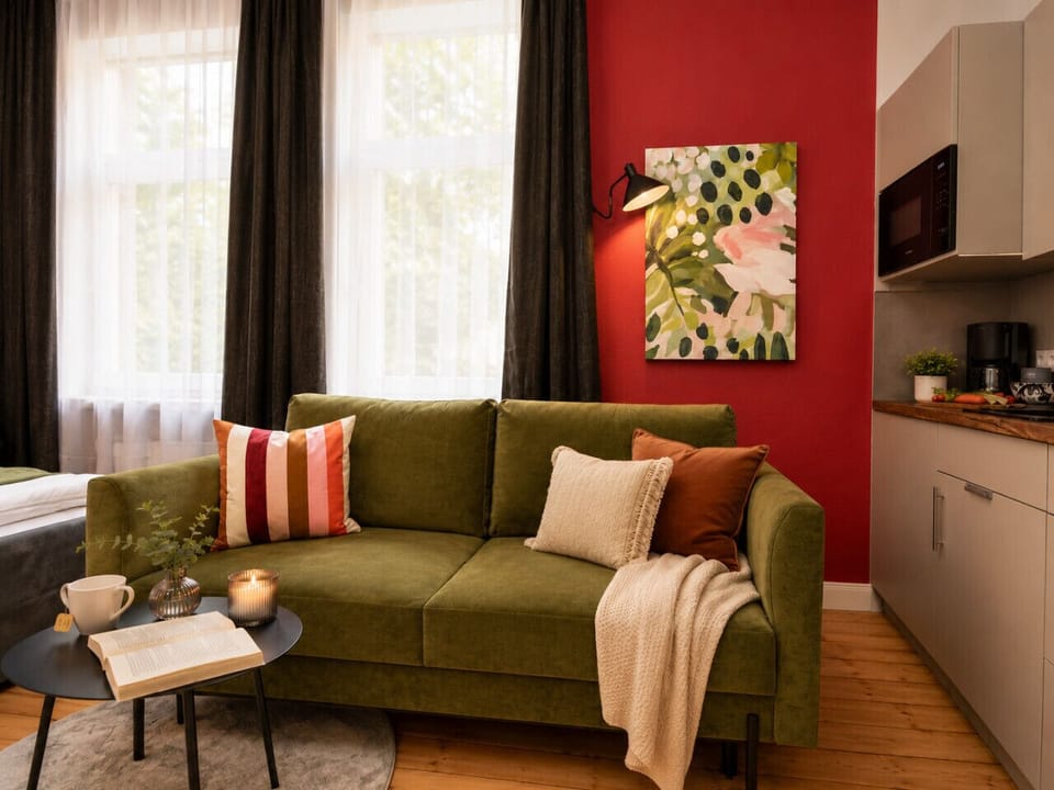 Unwind in this stylish living space with a comfortable sofa, bright windows, modern décor, and convenient access to the kitchenette for a true home-away-from-home experience.