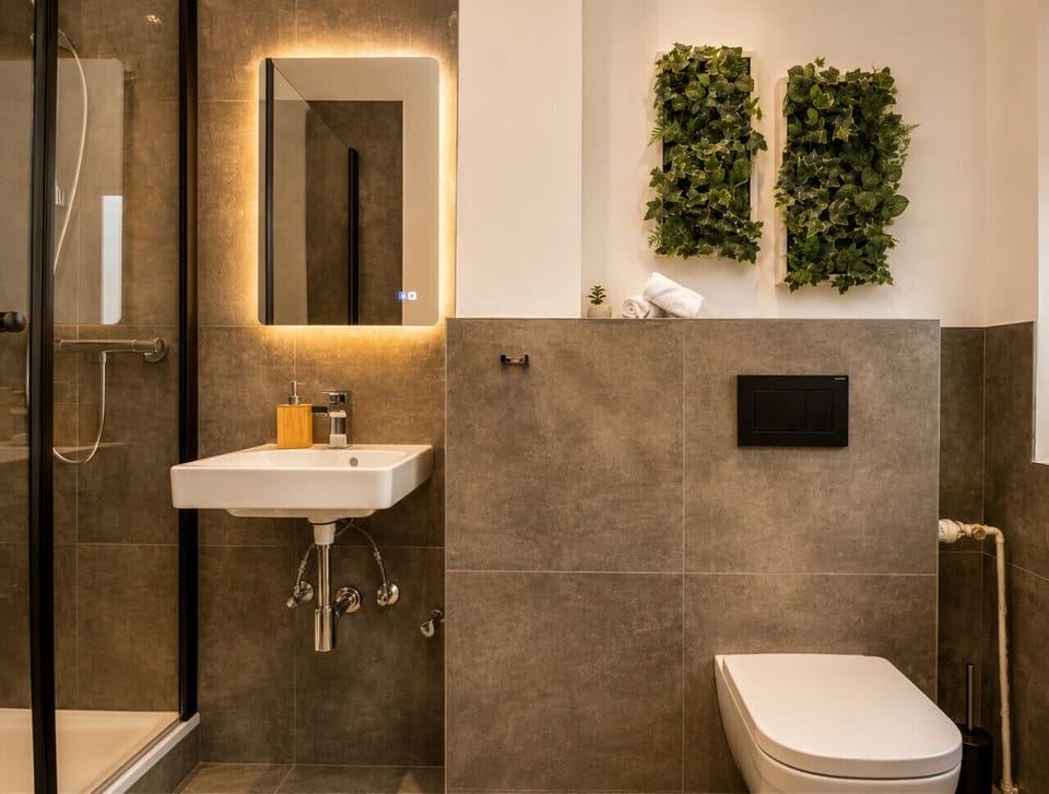 Enjoy a beautifully designed bathroom with a spacious walk-in shower, sleek vanity, modern lighting, and thoughtful details that enhance your stay.