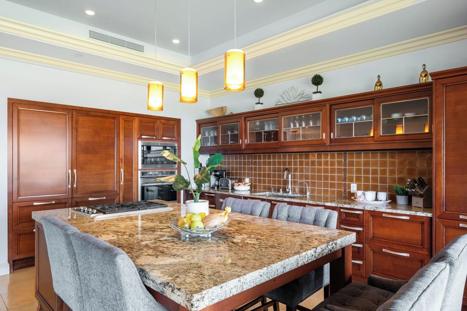 This beautifully designed kitchen features rich wood cabinetry, granite countertops, and cozy bar seating—perfect for morning coffee or evening meals in style
