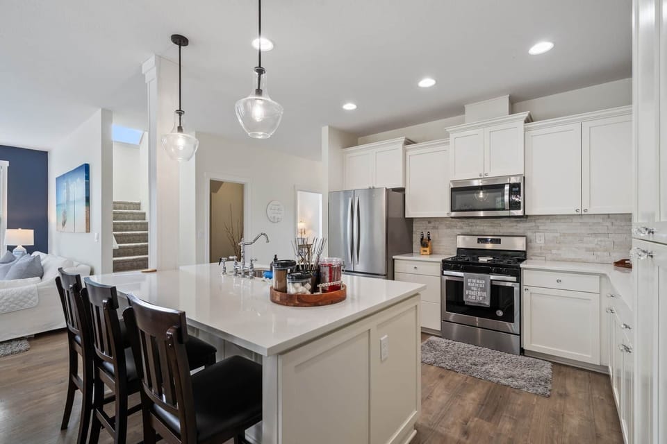 Large modern kitchen with quartz countertops, stainless steel appliances.