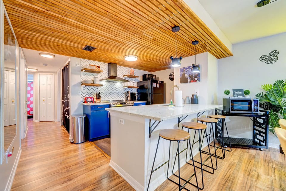 Modern kitchen with a wooden ceiling and a breakfast bar with stools.