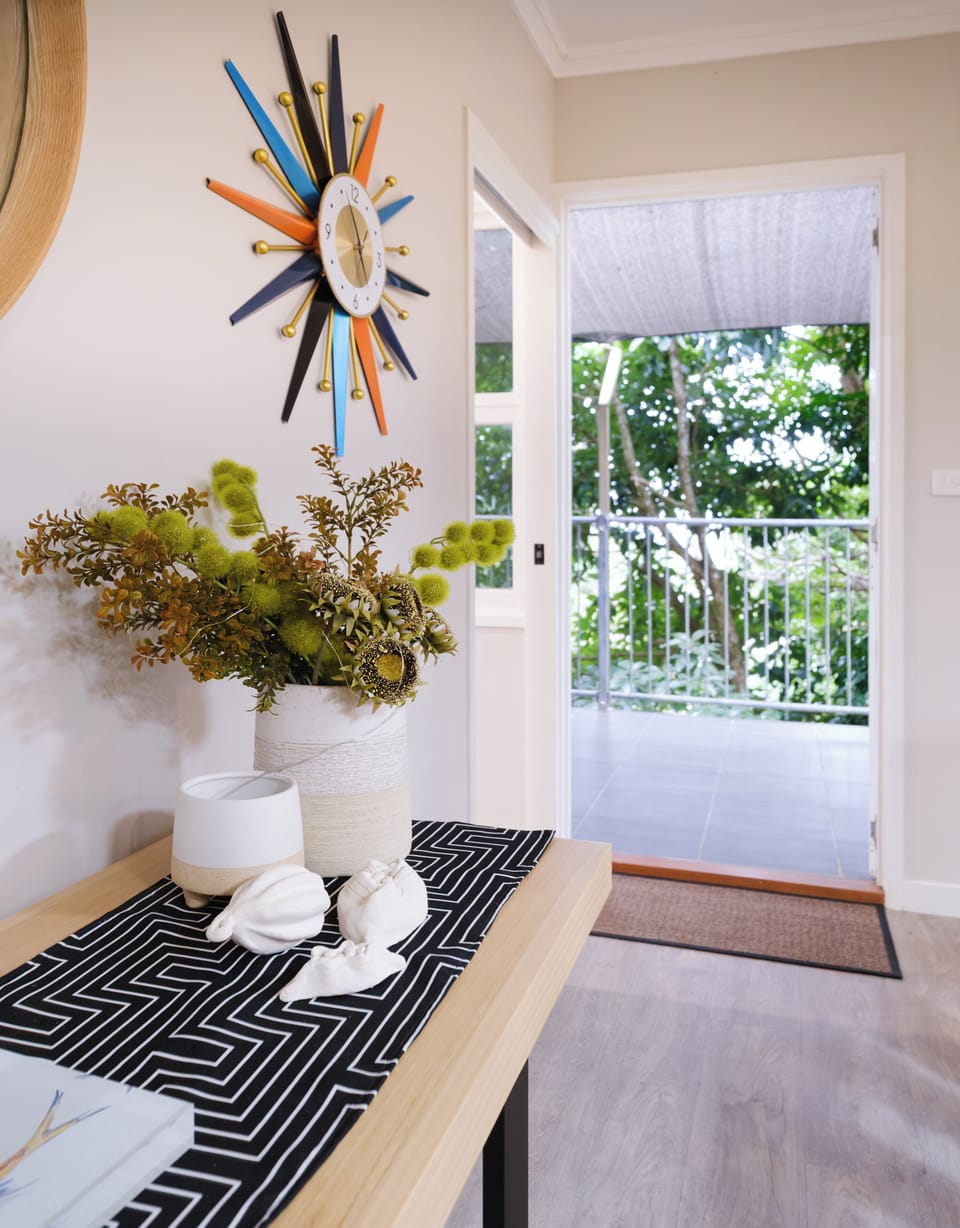 Hallway to upstairs balcony, kitchen and dining to right, main b/room to left