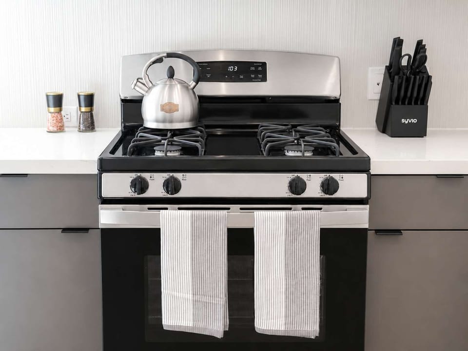 Experience extended comfort with a fully equipped kitchen featuring a coffee machine, stovetop, and microwave—everything you need for a seamless long-term stay