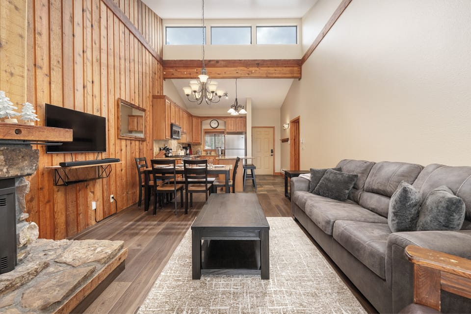 Unwind in your cozy living space with soaring wood ceilings and a stone fireplace, where mountain charm meets modern comfort.