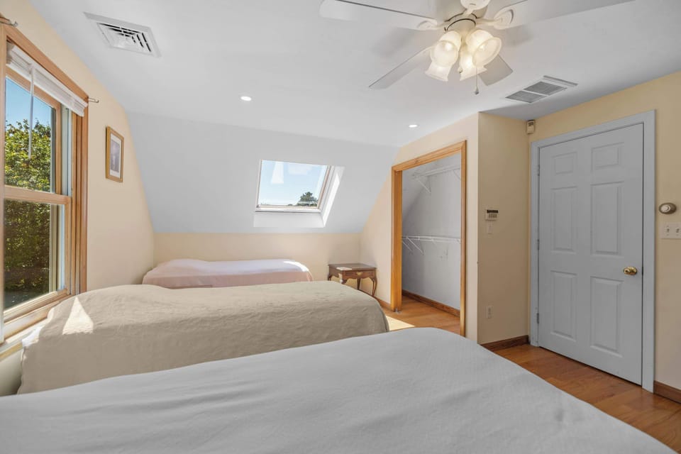 Upstairs bedroom with twin beds and skylight for natural light