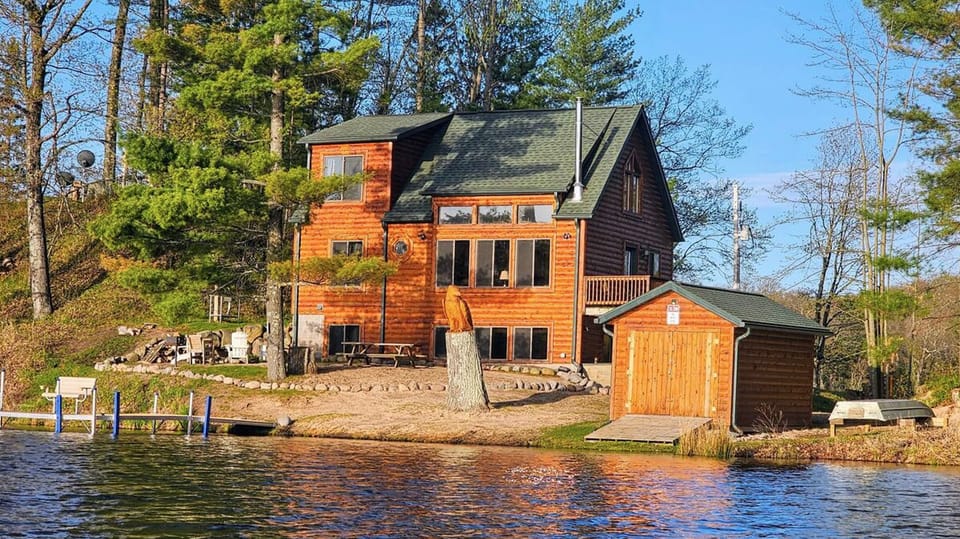 Cabin, boat house, and dock steps from the water. 