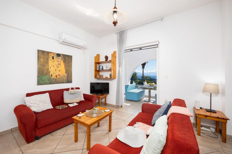 Open-plan living room with sofas, dining area, kitchen, A/C, WiFi internet, satellite TV, and sea views