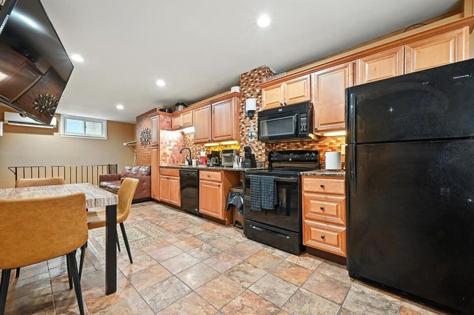 A spacious kitchen with a dining area, featuring a full suite of appliances and a beautiful tiled backsplash, ready for your culinary adventures.