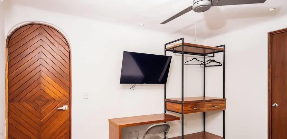 Escritorio pequeño, TV plana y clóset para colgar tu ropa