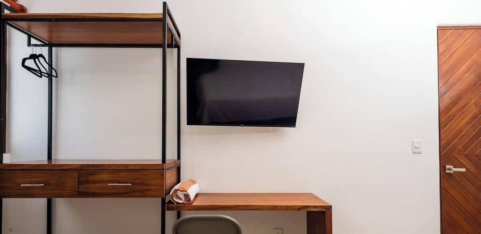 Habitación con esencial escritorio , tv plana y clóset