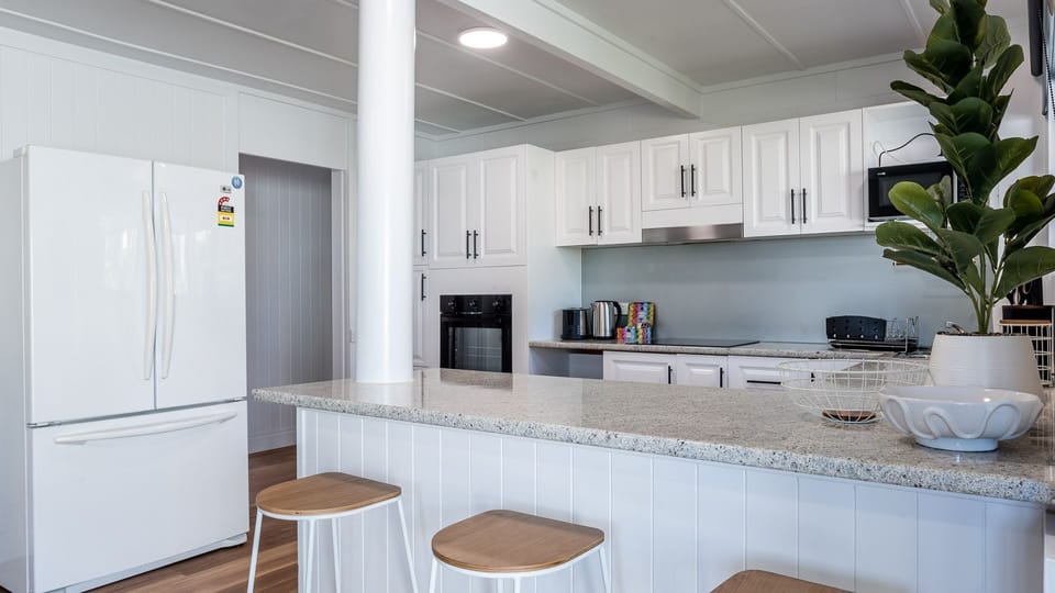 Contemporary kitchen with refrigerator, breakfast bar, and stools