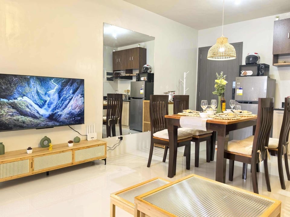 Modern dining area with kitchen, smart TV, and cozy setup for relaxing stays.