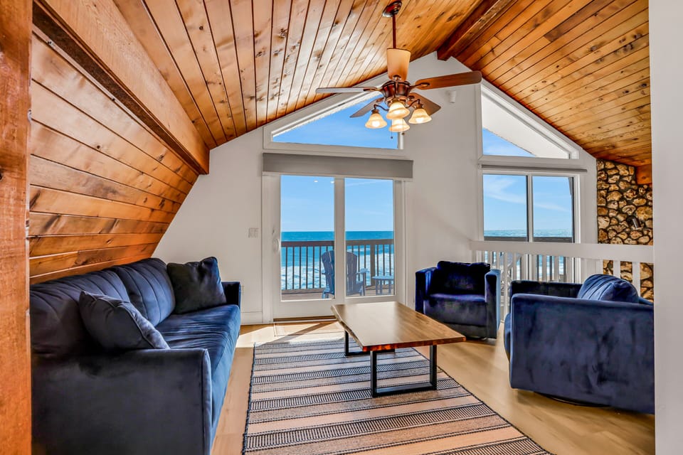 Relax in the upper lounge, featuring dramatic vaulted wood ceilings, plush seating, and expansive windows facing the Atlantic.