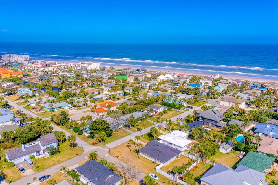 Aerial view of the coastal neighborhood with easy beach access, surrounded by charming homes and just steps from the shoreline.