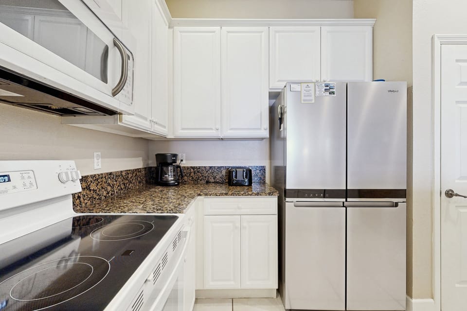 A fully equipped kitchen with modern appliances and a spacious breakfast bar, ideal for quick morning meals.