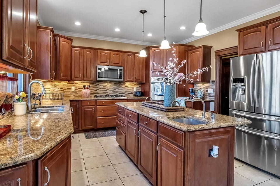 Chef’s kitchen with granite counters, stainless appliances, and large island.